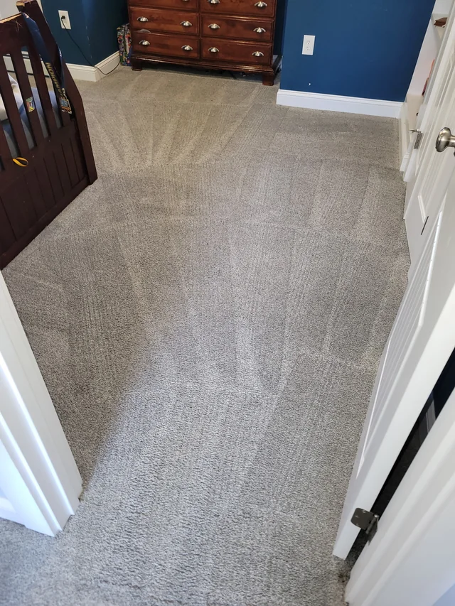Cleaned bedroom carpet beside blue walls