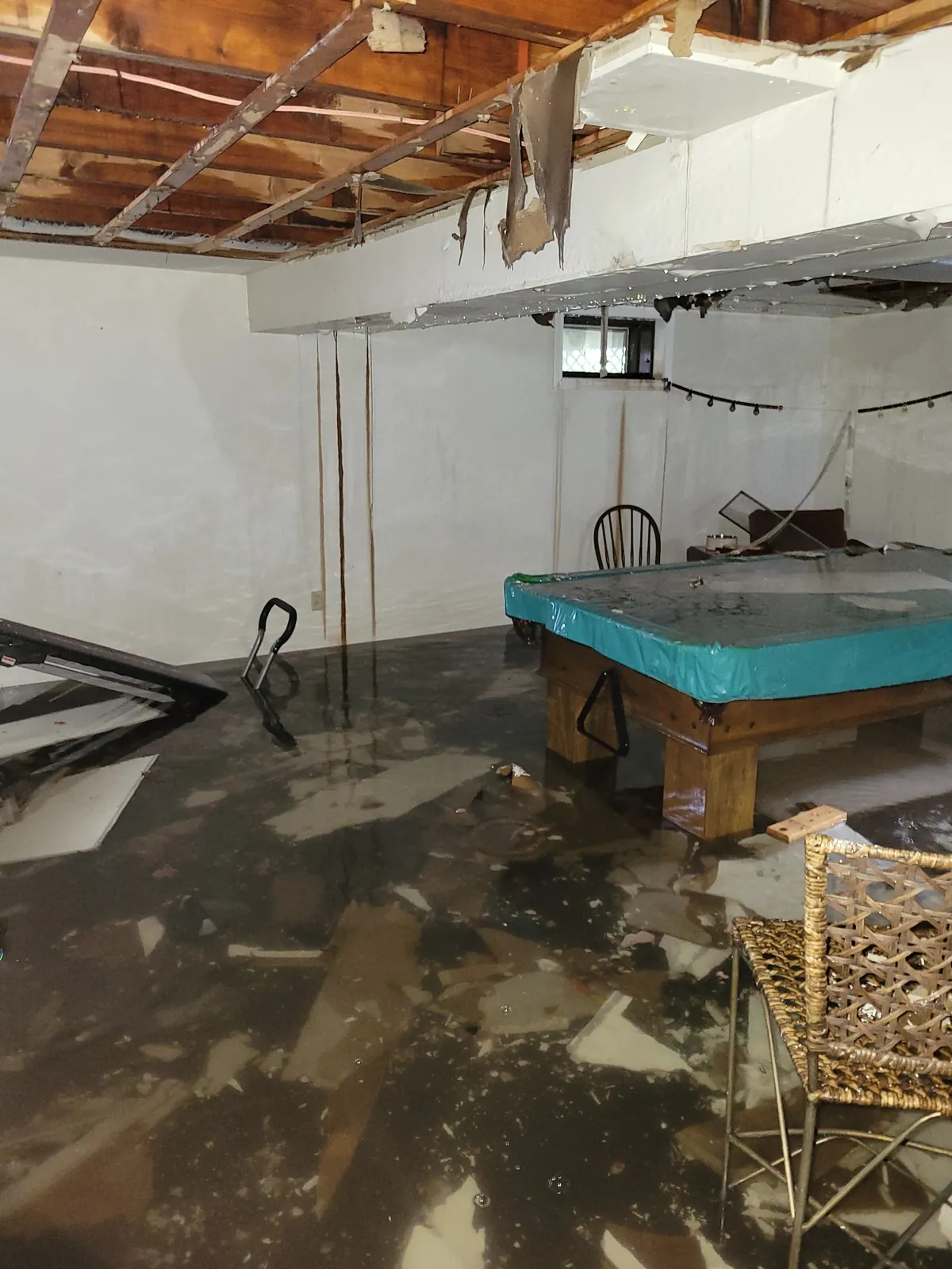 Standing water across a basement after water damage.
